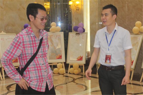 20140530204316948 888集团电子游戏网络营销主管王宏城(右一)向记者介绍微晶瓷片
